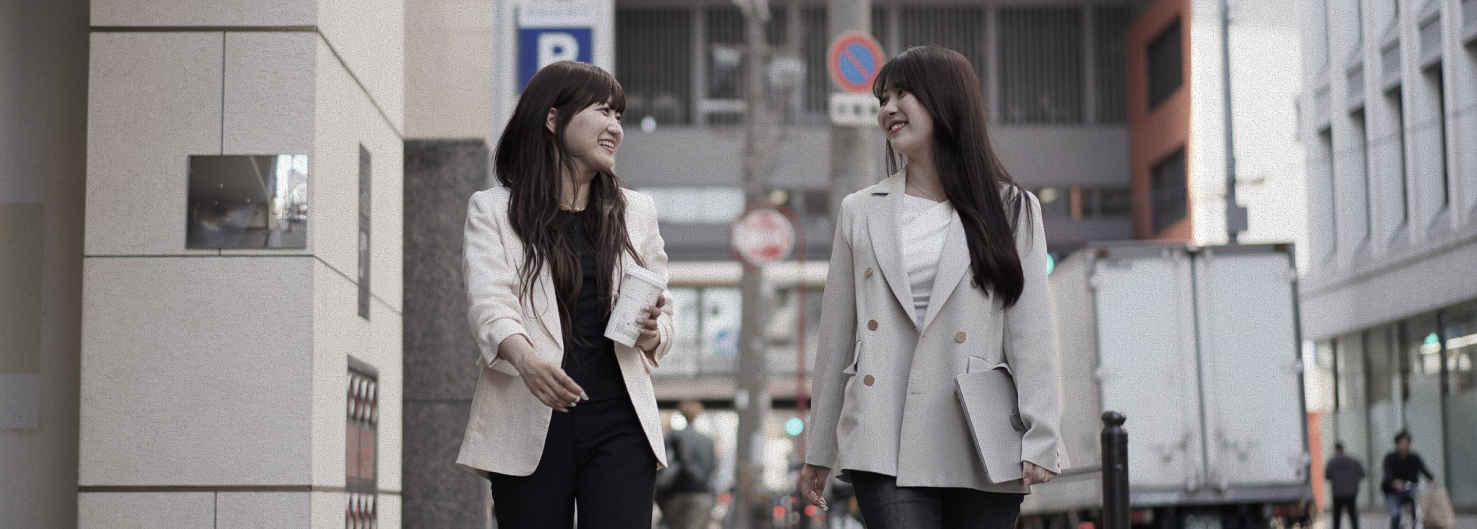 街を歩きながら話す2人の社員