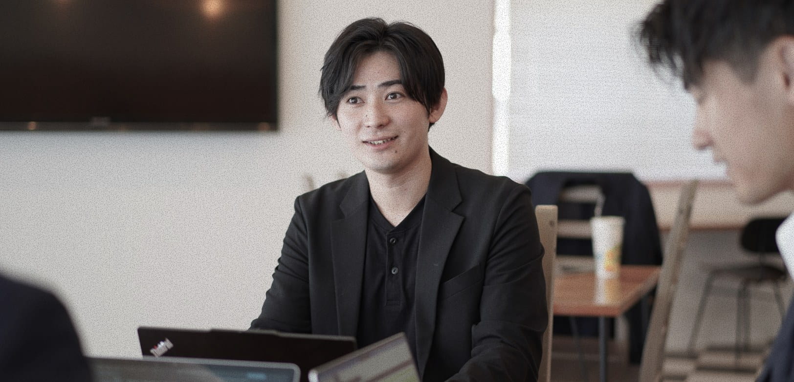 カフェスペースで同僚と話す様子