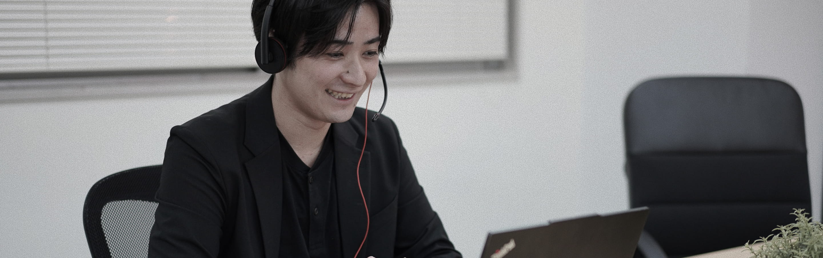 ヘッドセットを着けてデスクで働く様子