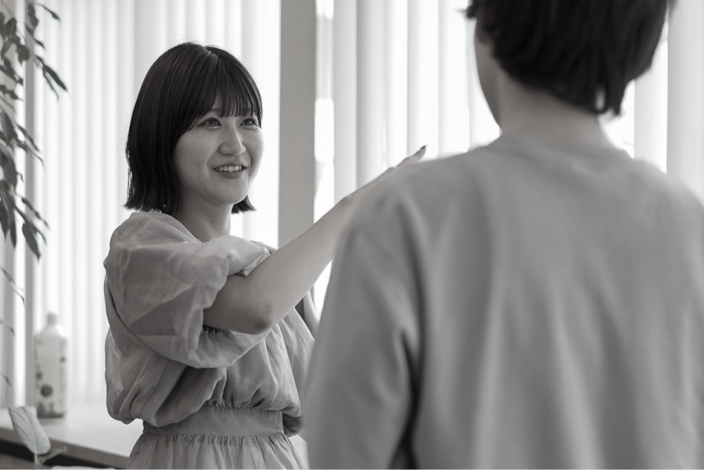 窓際で同僚と談笑する社員
