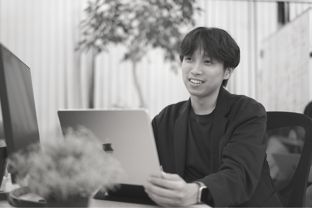 ノートパソコンを前に打ち合わせをする社員
