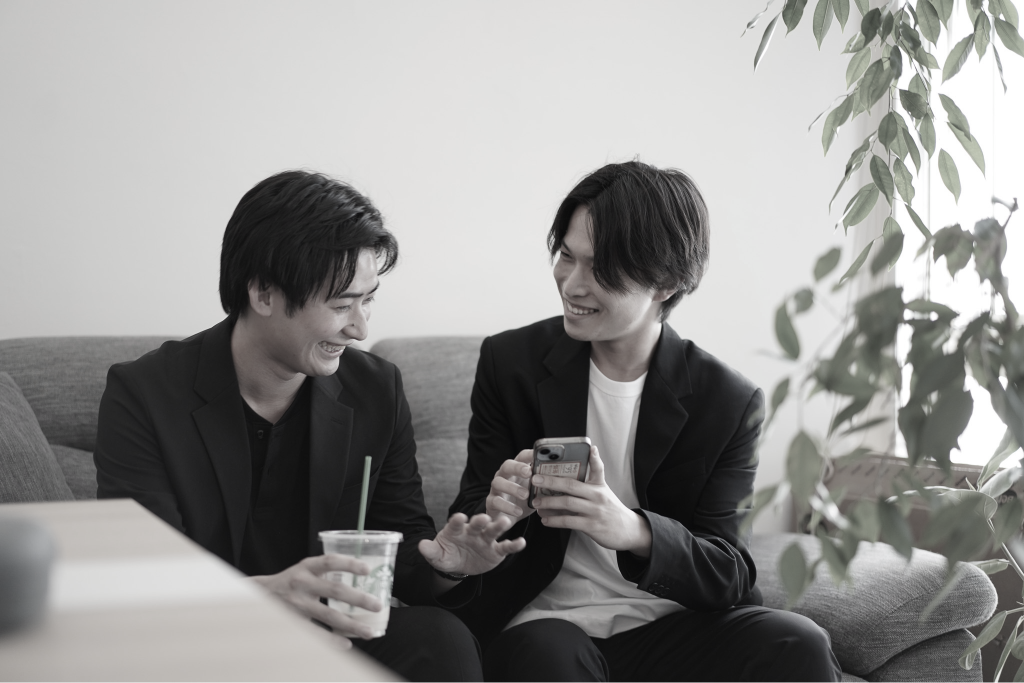 スマートフォンを見ながら談笑する社員