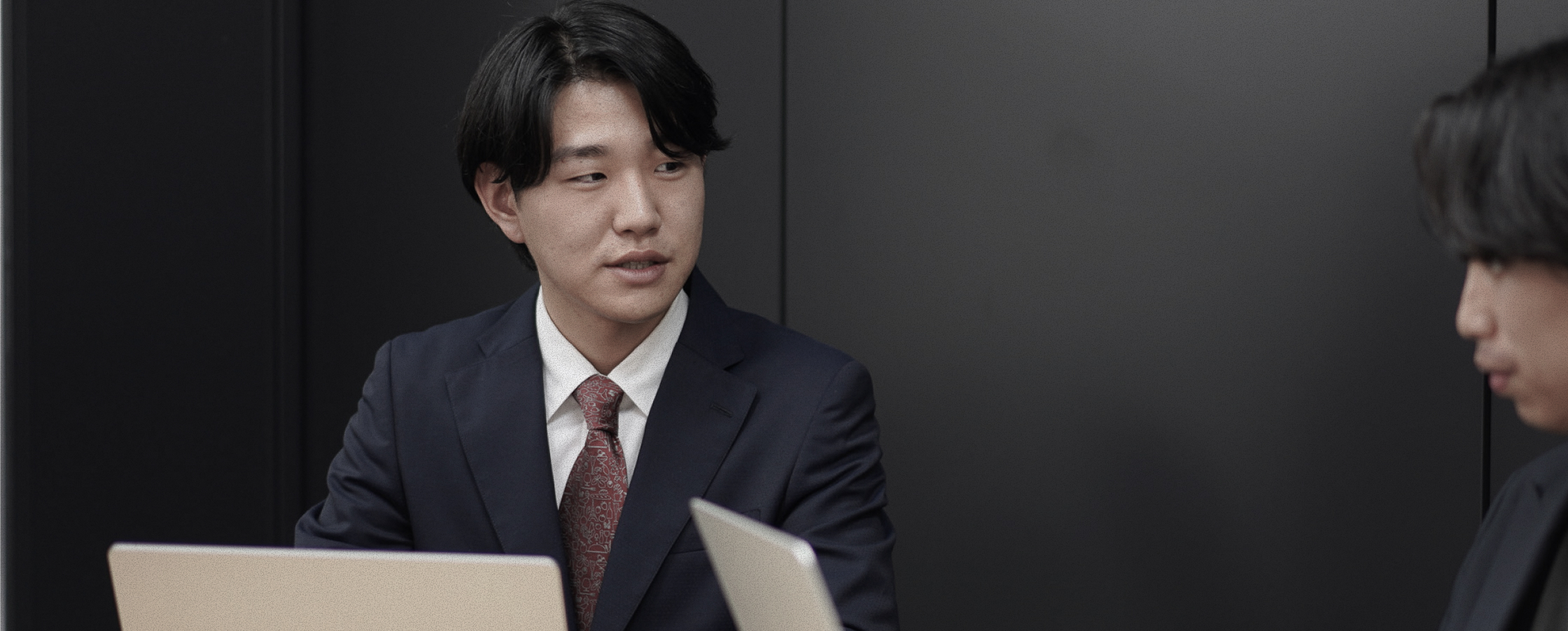 会議室でノートパソコンを前に商談する社員